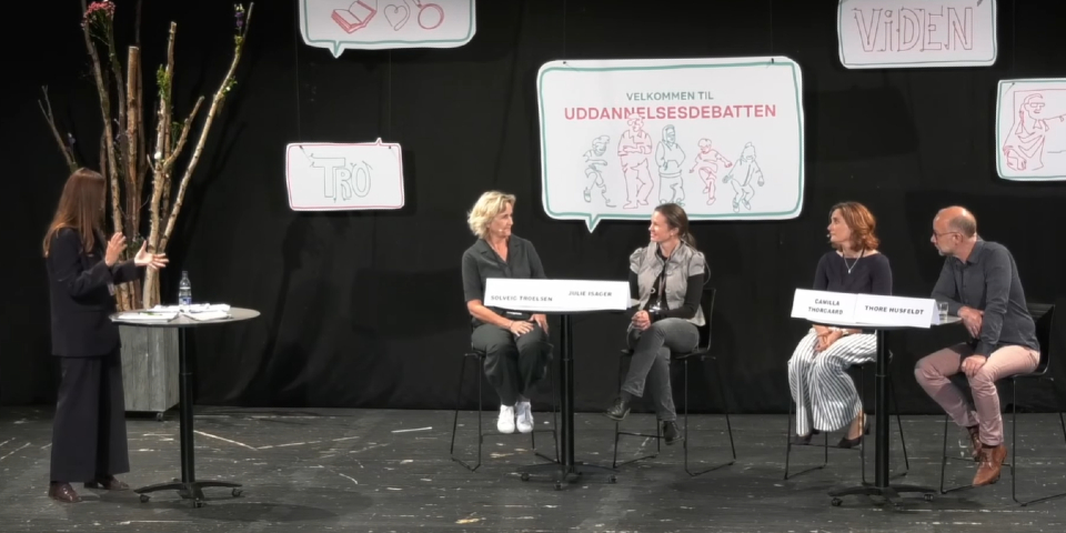 Fire personer og moderator snakker på scene