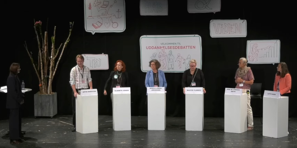 Mennesker står ved podier og snakker