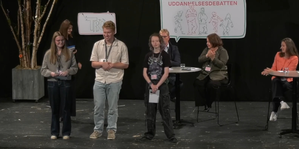 Tre unge mennesker står på scene og snakker